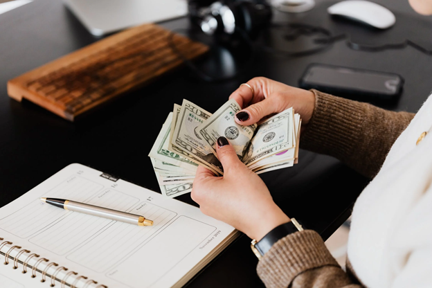 woman counting money at desk