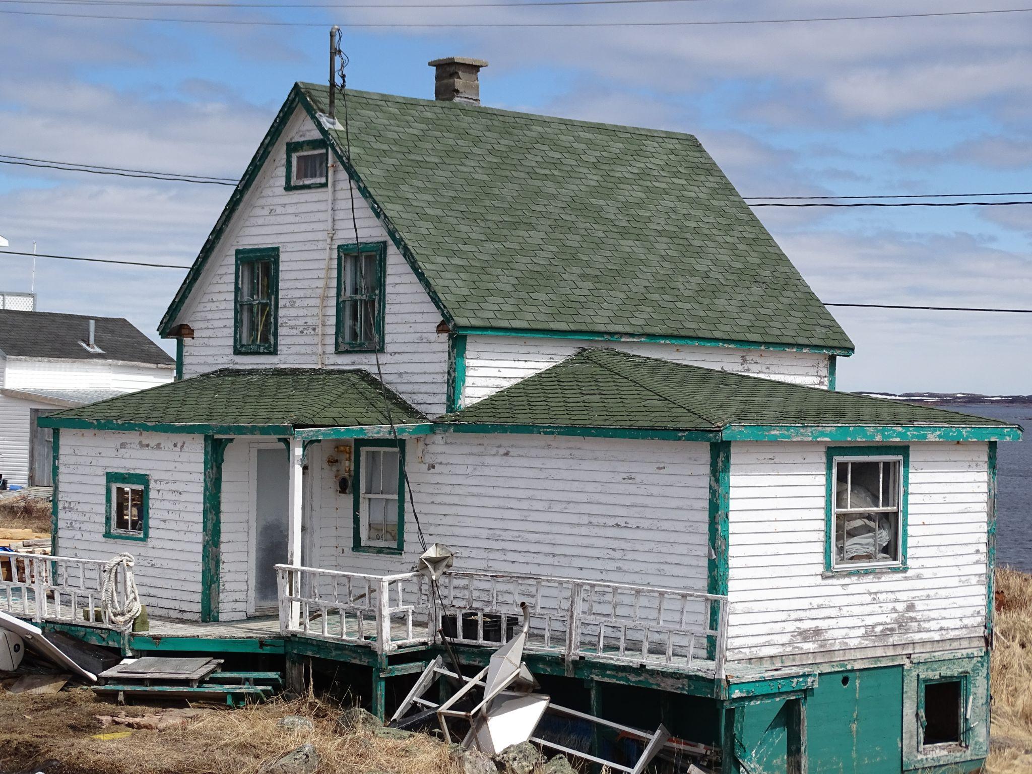 ugly house with broken windows and railing