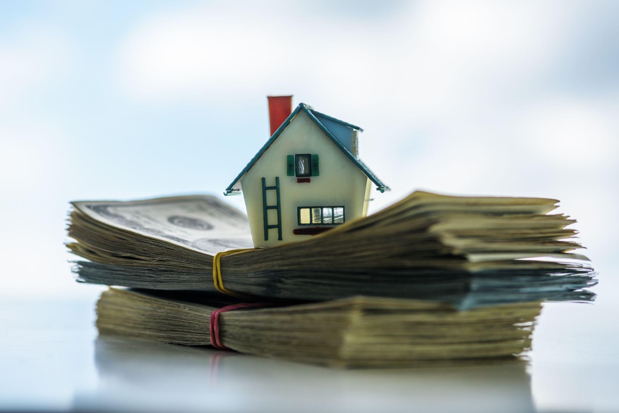 Visual representation of real estate agent fees: a house on a cash