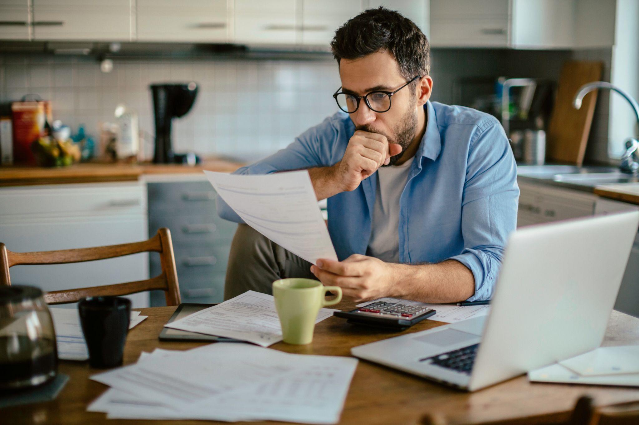 Man looking at bills concerned he won't be able to pay his mortgage