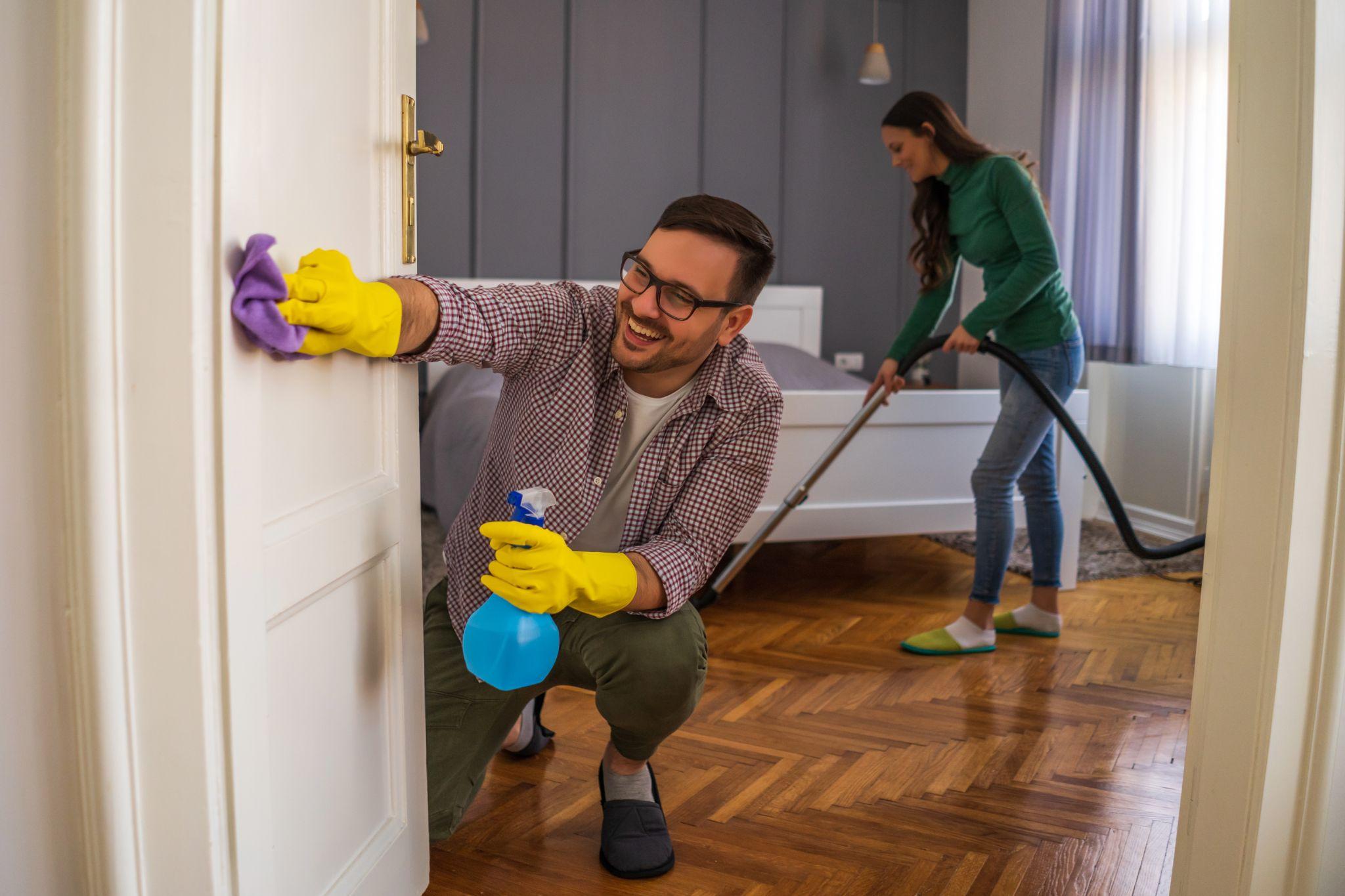 A couple cleaning a house before listing it for sale