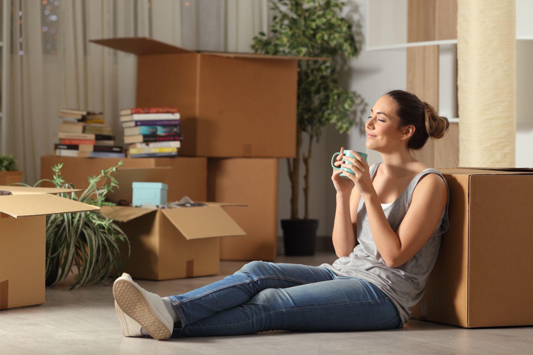 A woman relaxing with moving boxes behind her