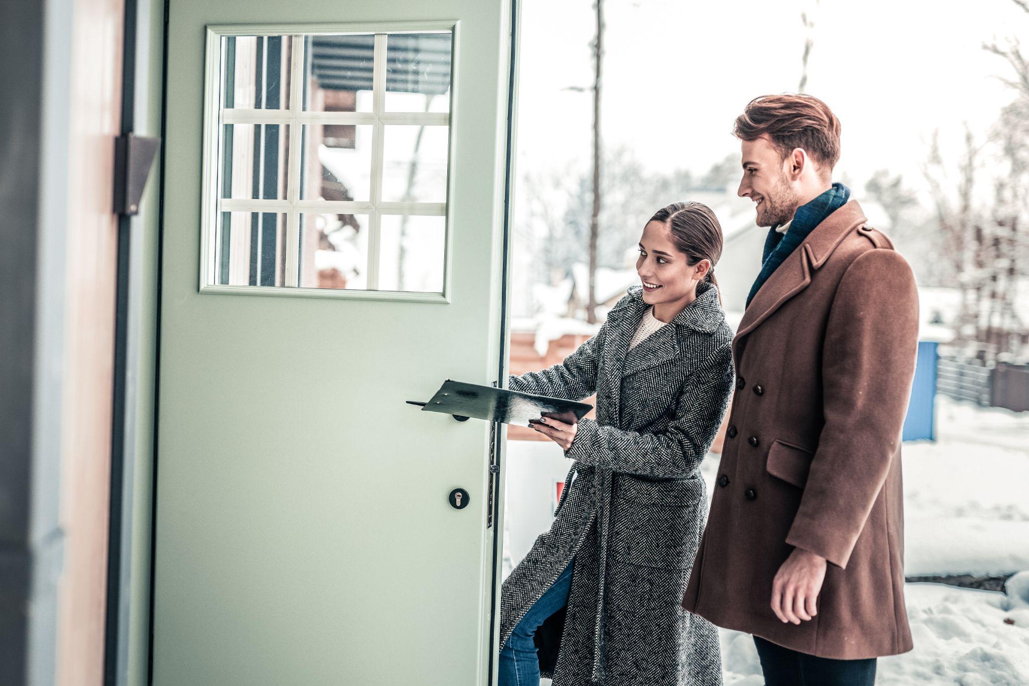 An agent and a man entering a house for a tour
