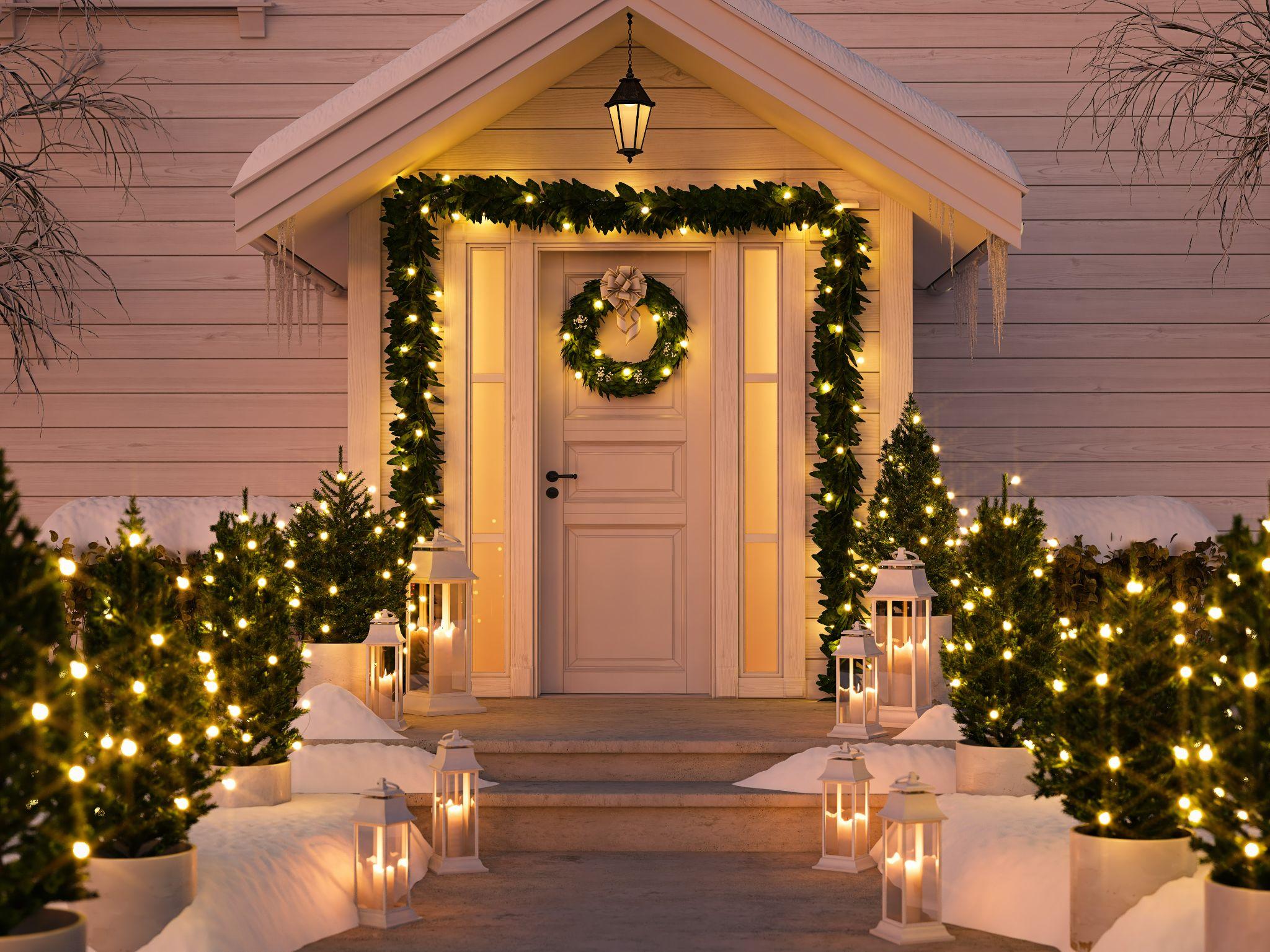 christmas decorated porch with little trees and lanterns.