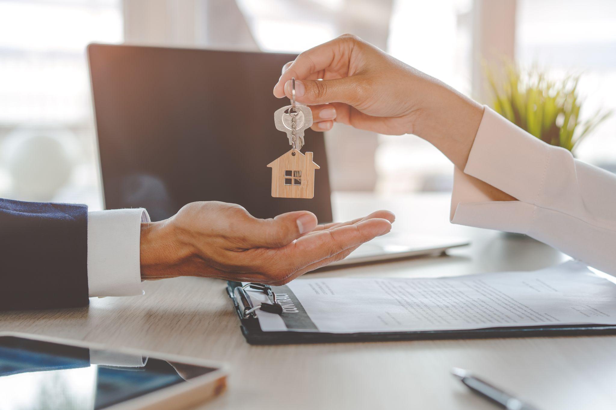 Close up view home keys in the agent hand giving to new owner.