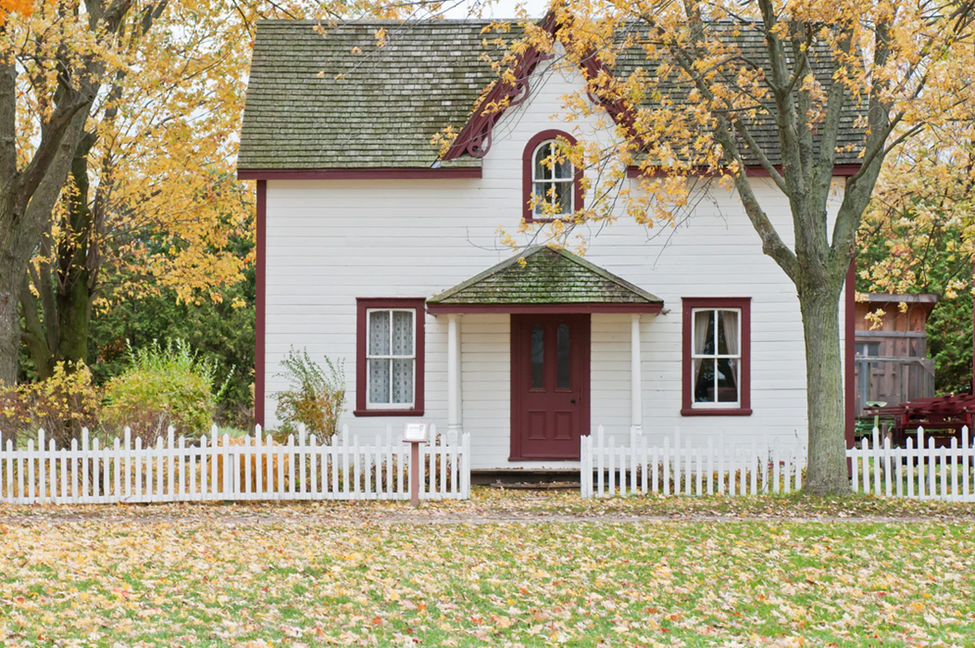 front lawn of a small two story red and white house