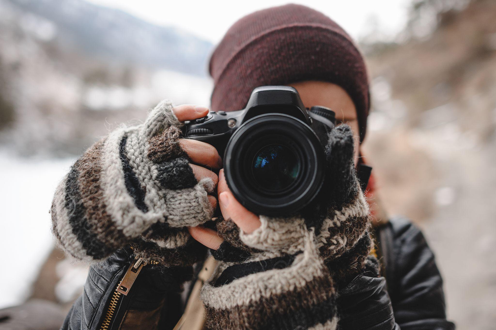 Photographer taking a picture of a house in winter